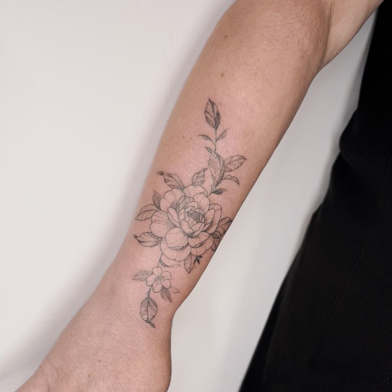 Fineline pioenroos lichte schaduwen maken deze tattoo stijl gewild